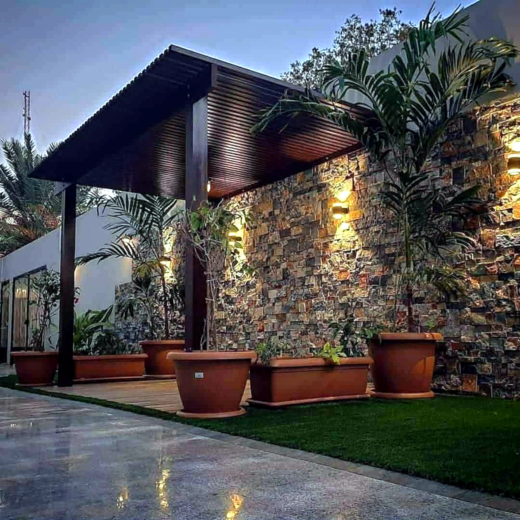 تصميم برجولة مع جدار حجري ضمن لاندسكيب حدائق بالرياض